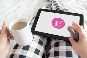 Tablet auf Beine mit Kaffeetasse in der Hand