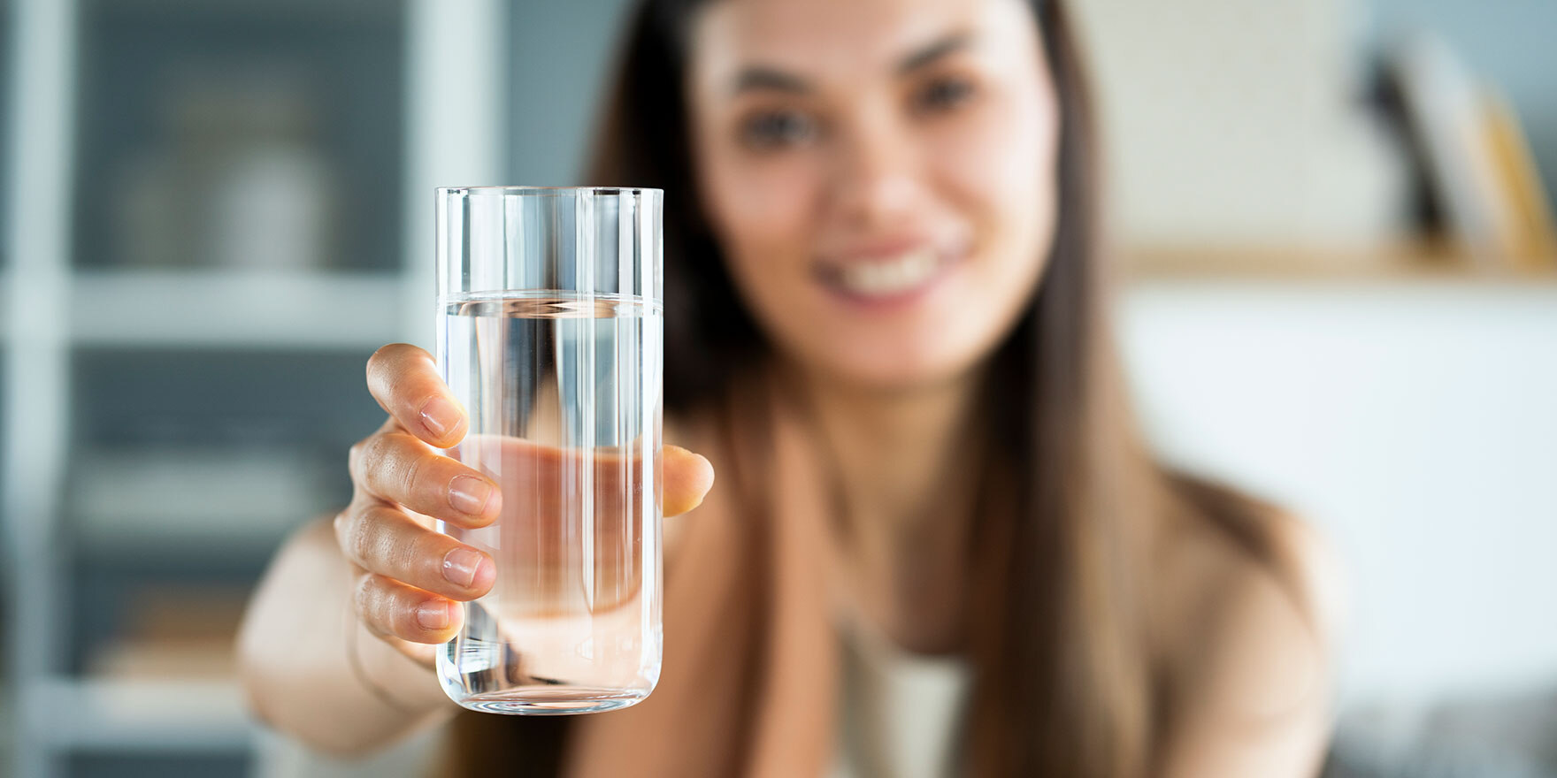 Junge Frau hält ein Glas Wasser